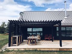 an outdoor patio with table and chairs under a metal roof