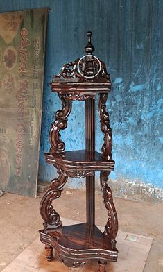 an ornate wooden shelf in front of a blue wall