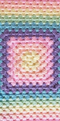 a crocheted square is shown in pastel colors