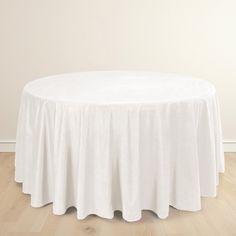 a white round table with a pleated skirt