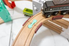 a toy train set with wooden tracks and cars