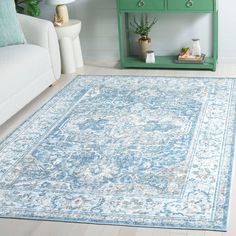 a blue and white rug in a living room with a green table next to it