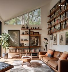 a living room filled with lots of furniture and bookshelves next to a window