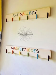 three wooden pegs are attached to the wall with words on them that read art gallery and masterpiece