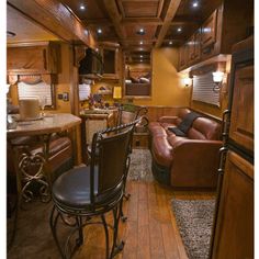 the inside of a motor home with wood flooring and leather couches in it