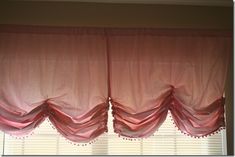 the pink curtains are hanging in front of the window