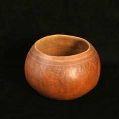 a wooden bowl sitting on top of a black surface