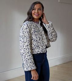 a woman is smiling and talking on her cell phone while standing in an empty room