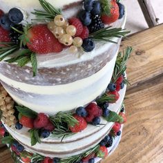 a multi layer cake with berries and pineapples on top