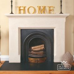 a fireplace with a sign that says home on top of it and some candles in front of it