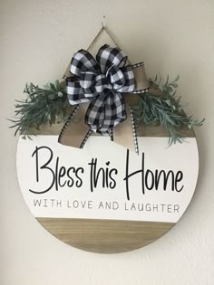 a wooden sign with a bow hanging from it's side that says, bess this home with love and laughter