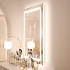 a white dresser topped with a mirror and lights