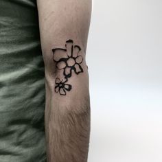 a man's arm with a tattoo on it that has flowers in the middle