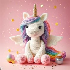 a crocheted stuffed unicorn sitting next to a jar of confetti on a pink background