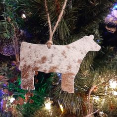 a cow ornament hanging from a christmas tree