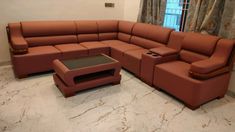 a living room with a large sectional couch and coffee table in it's center