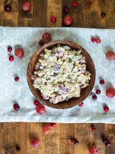 a wooden bowl filled with fruit salad on top of a table