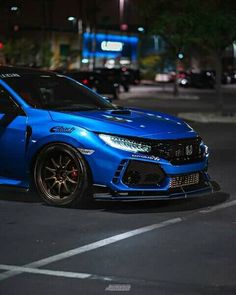 a blue car parked on the street at night