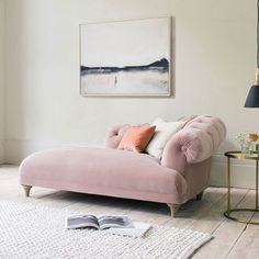 a pink chaise lounge in a white living room