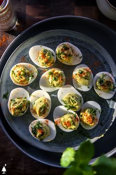 an overhead view of deviled eggs with garnish and seasoning on them