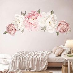 a bedroom with pink and white flowers on the wall