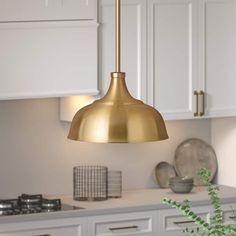 a kitchen with white cabinets and gold pendant light