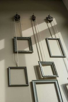 several frames are hanging on the wall next to each other, and one is empty