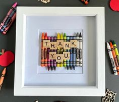 a white frame with some crayons on top of it next to other crayons