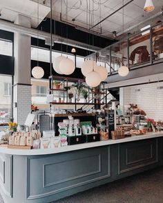 an open kitchen with lots of counter space and hanging lights