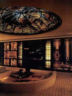 a living room filled with furniture and a large stained glass window