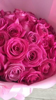 a bouquet of pink roses in a paper box