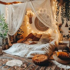 a bed with lots of pillows and blankets on it, surrounded by lights that are hanging from the ceiling