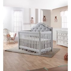 a baby crib in a room with white furniture