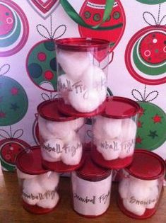 a stack of plastic containers filled with snowballs on top of a wooden table next to a christmas themed wallpaper