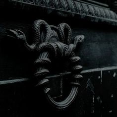 a black and white photo of an old door handle with rope wrapped around the handles