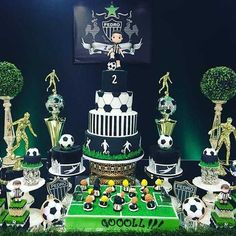 a soccer themed birthday cake and cupcakes on a green tablecloth with decorations