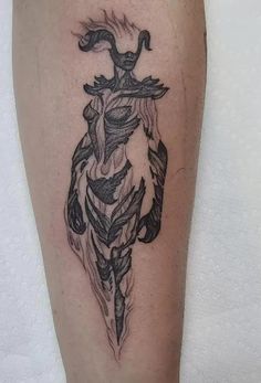 a black and white tattoo on the leg of a person's leg, with an arrow