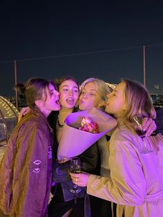 four girls are posing for the camera at night