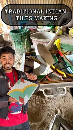 a man holding up a piece of paper in front of a pile of pots and pans