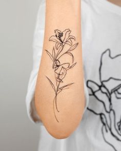 a woman's arm with a flower tattoo on the left side of her arm