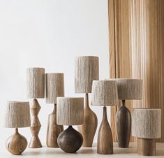 several wooden vases and lamps on a table