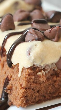 a piece of cake with white frosting and chocolate chips