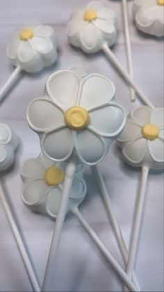 several white and yellow flower shaped lollipop sticks