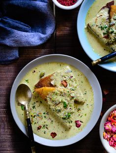 two bowls filled with soup on top of a wooden table