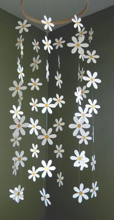 a mobile made out of paper with flowers hanging from it's sides in a room