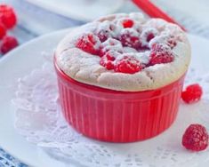 a dessert with raspberries and powdered sugar on the top is ready to be eaten