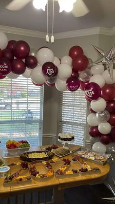 a table topped with lots of food and balloons