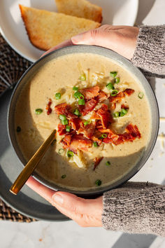 hands holding roasted cauliflower cheddar soup Cauliflower Cheddar Soup, Cauliflower Cheddar, Recipe For Lunch, Make Bacon, Diced Potatoes, Cheddar Soup, Crumbled Bacon, Green Onion, Roasted Cauliflower