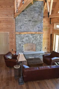 a living room with leather furniture and a stone fireplace