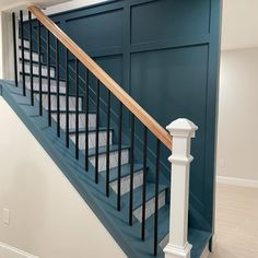 an empty room with blue walls and white stairs